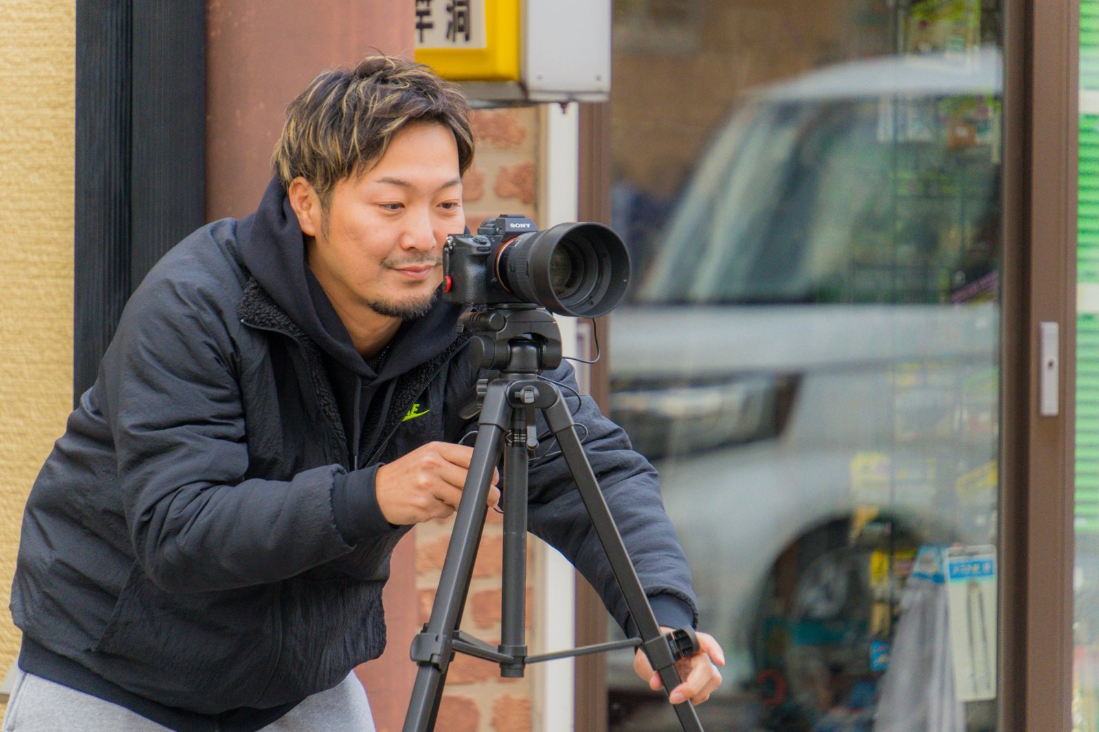 三脚にカメラを構えて撮影する、フォトグラファーのひろ