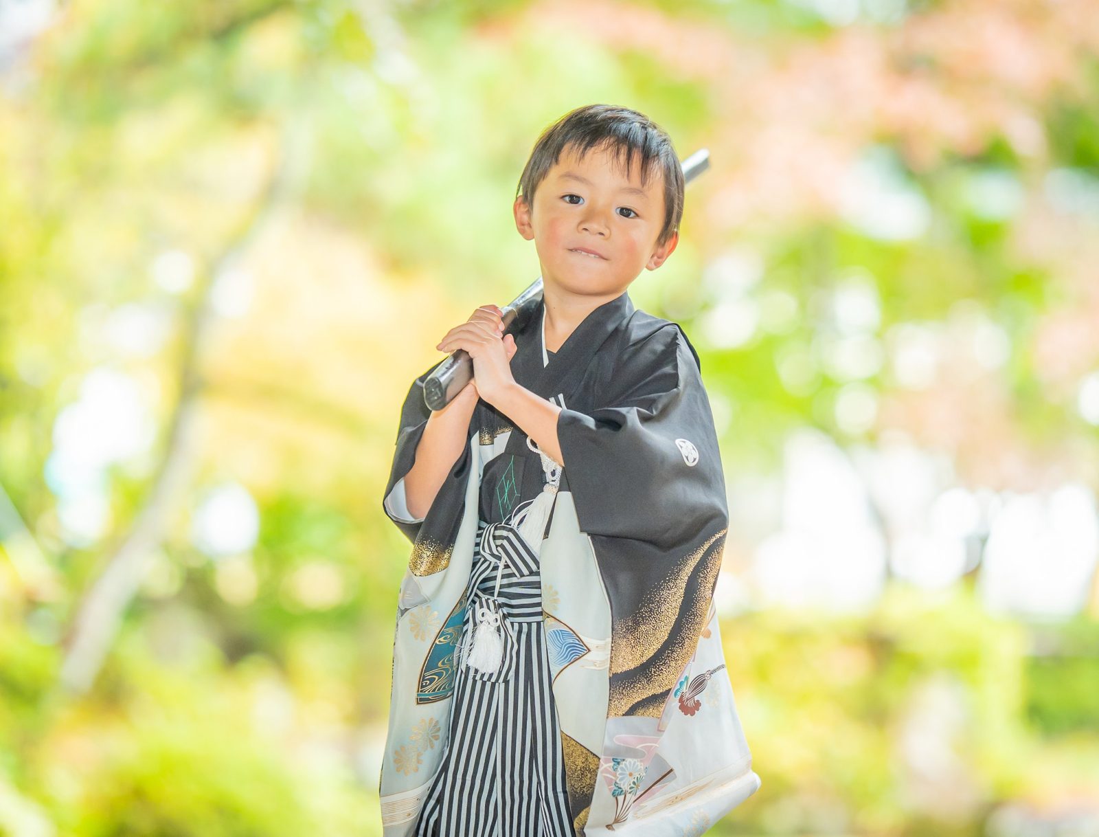 刀を肩にかついで凛々しく立つ男の子