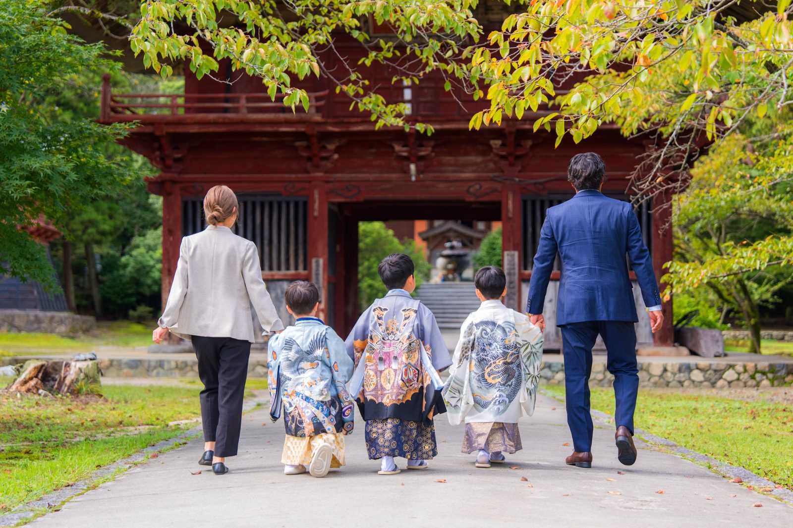 お寺の山門へ向かって歩く5人家族