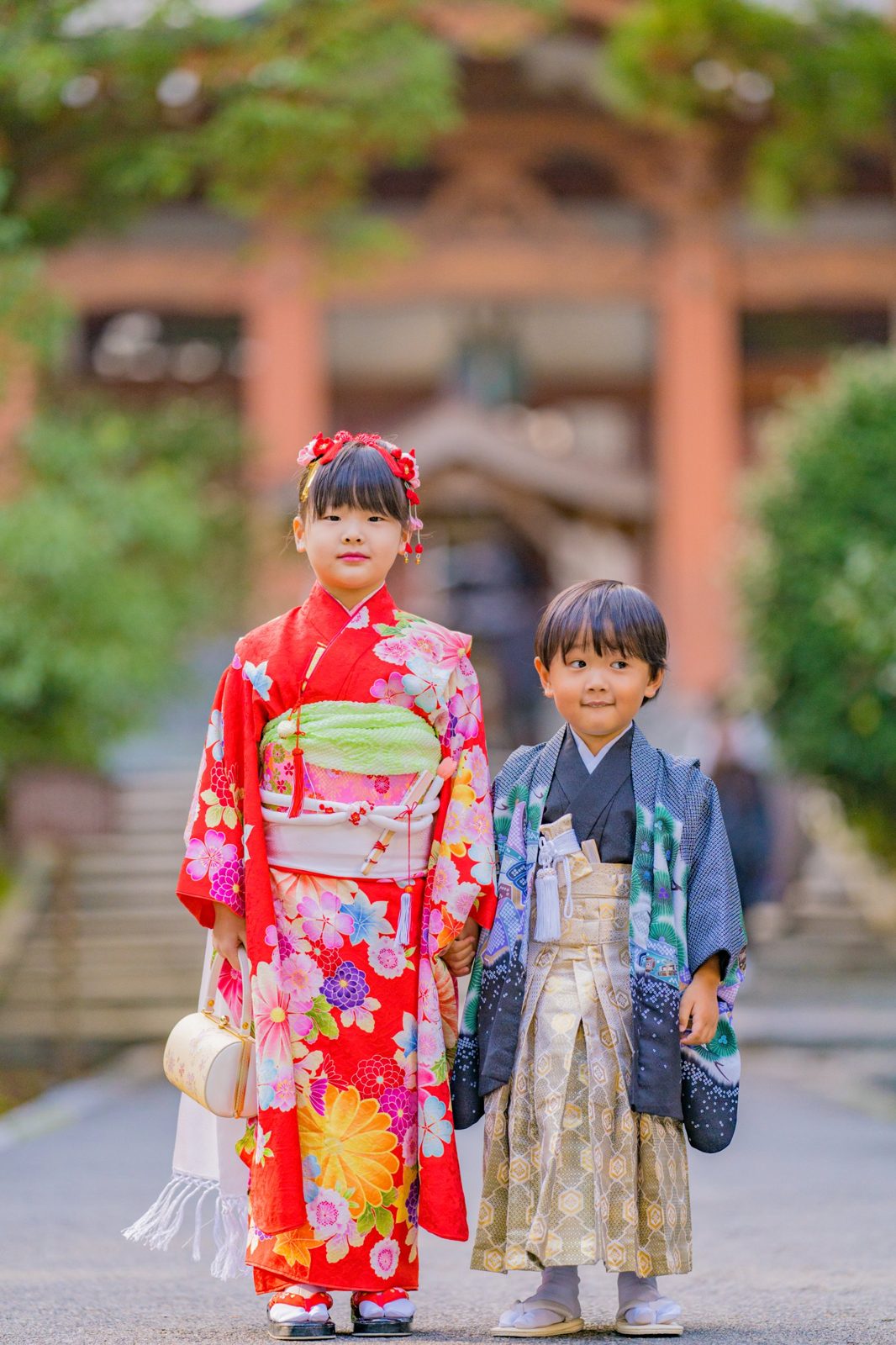 お寺の参道に並んで立つ、着物姿の姉弟