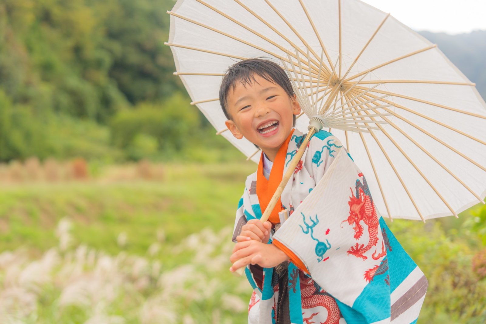 和傘を持って大笑いする男の子