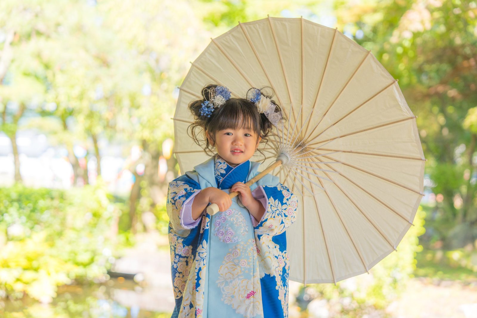 やわらかい光の中、和傘を持つ七五三の女の子